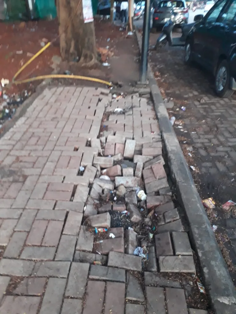 क्लब रोड पदपथावरील पेव्हर्स उखडल्याने समस्या Problem due to dislodgement of pavers on Club Road footpath