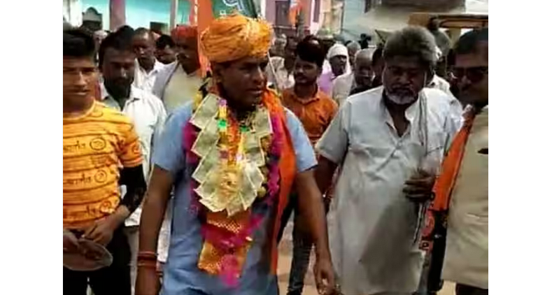 'MLA' mention on the car, currency necklace around the neck