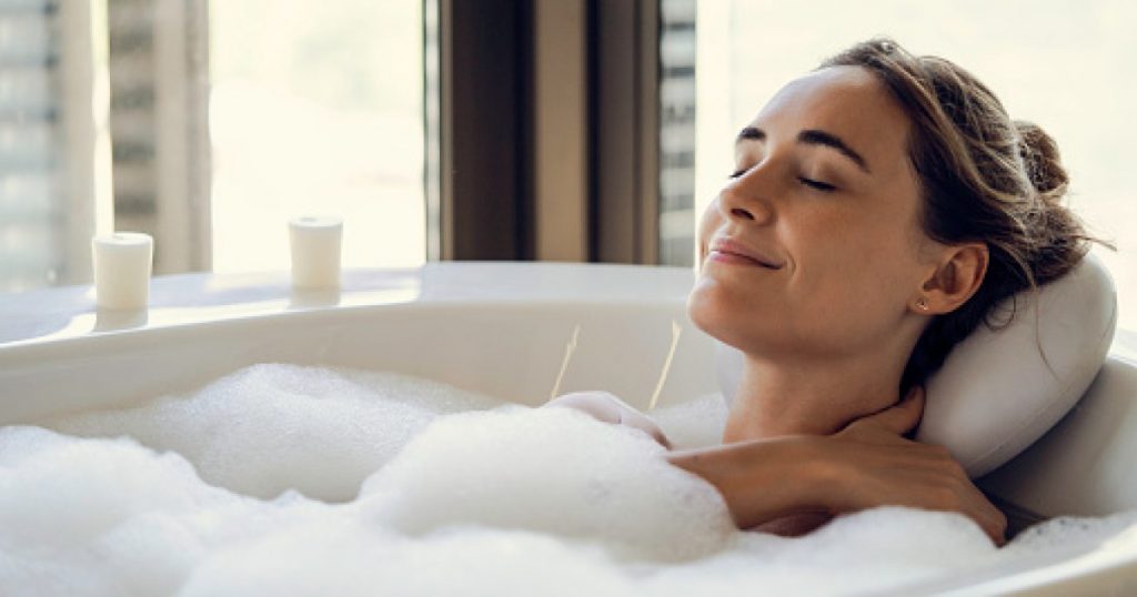 The act of lying in a bathtub